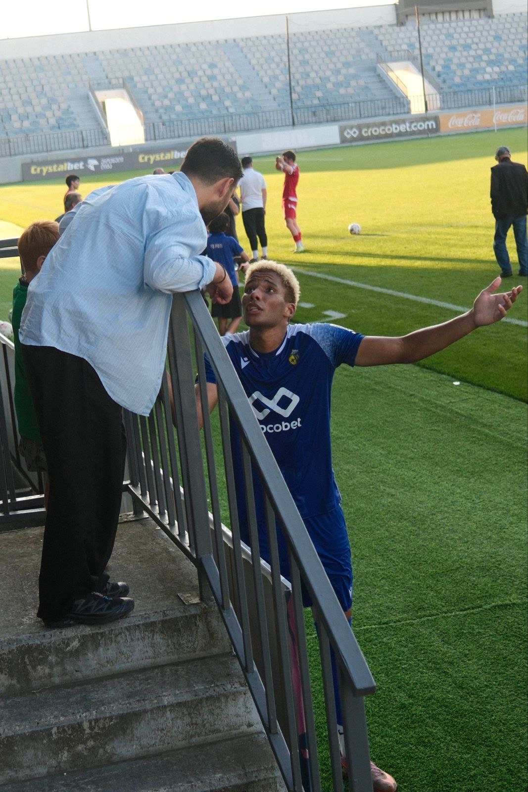 Gegi Kekua speaking with a GoalX player beside the pitch